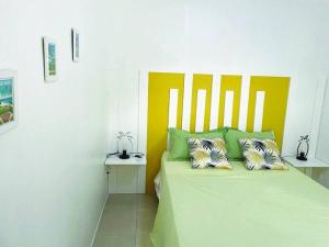 ein Schlafzimmer mit einem grünen Bett mit zwei Kissen in der Unterkunft Bel appartement dans écrin de verdure in Le Lamentin