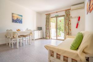 Una sala de estar y un comedor con mesa y sillas. en Apartamentos Playamar - Formentera Break, en Playa de Migjorn
