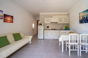 Una sala de estar con un sofá y una mesa y una cocina. en Apartamentos Playamar - Formentera Break, en Playa de Migjorn