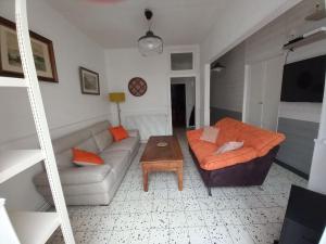 uma sala de estar com um sofá e uma mesa em Maison de pêcheur typique proche plage em Fécamp