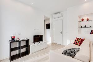 a white living room with a white couch and a tv at Hotel Anversa Rimini in Rimini