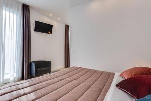 a bedroom with a bed and a chair and a window at Hotel Anversa Rimini in Rimini