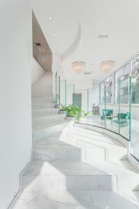 a hallway with white marble stairs and glass walls at Hotel Anversa Rimini in Rimini