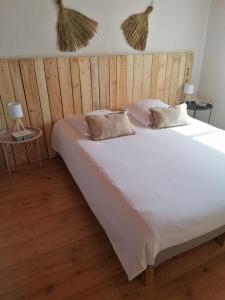 una camera da letto con un grande letto bianco con testiera in legno di Maison sur le Bassin d'Arcachon a La Teste-de-Buch