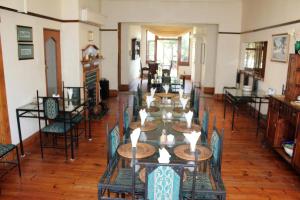 a dining room with wooden tables and chairs at Buckingham Place Guesthouse in Mount Road