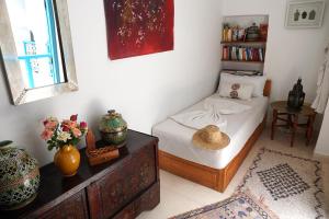 1 dormitorio con 1 cama y 1 mesa con flores en Dar Daoud, en Marrakech