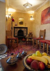 ein Wohnzimmer mit einem Tisch und Obst darauf in der Unterkunft Dar Daoud in Marrakesch