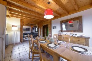 une salle à manger avec une grande table en bois et des chaises dans l'établissement ST JORIOZ- Cosy Chalet vue lac et montagnes - LLA Selections by Location Lac Annecy, à Saint-Jorioz