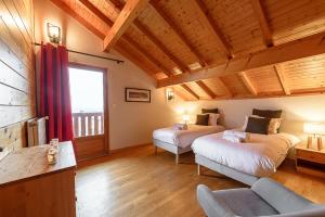 sypialnia z 2 łóżkami i kanapą w pokoju w obiekcie ST JORIOZ- Cosy Chalet vue lac et montagnes - LLA Selections by Location Lac Annecy w mieście Saint-Jorioz