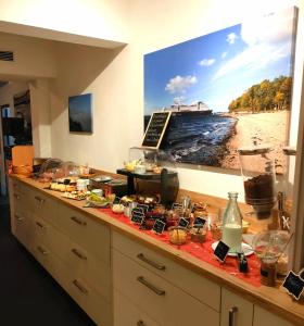 a counter with food and a picture of a river at Hotel O'felder in Osterrönfeld