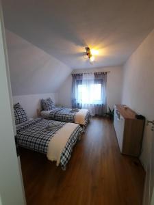 two beds in a small room with a window at Apartments 'Niko' in Waldsee