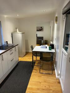 a kitchen with a table and a refrigerator at Tranquil Gardens in Loughborough