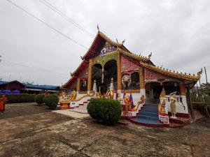 a small temple with paintings on the front at Manilath guesthouse in Ban Houayxay