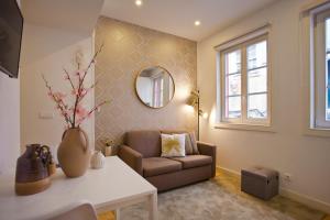 a living room with a couch and a mirror at São Bento Golden Flat in Porto