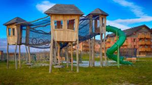 a playground with a slide and two play structures at Tatragolf Mountain Resort in Veľká Lomnica