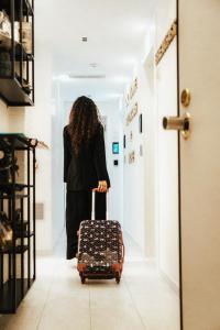 a woman walking down a hallway with a suitcase at Ok Home Pescara Rooms in Pescara