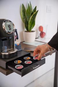 a person is pressing a button on a coffee machine at Ok Home Pescara Rooms in Pescara