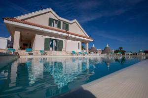 una villa con piscina di fronte a una casa di exclusive luxury villa monte pompilio a Ceglie Messapica