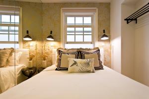 a bedroom with a large white bed with pillows at São Bento Golden Flat in Porto