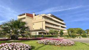 un grande edificio con fiori di fronte di Hotel Old River a Lignano Sabbiadoro