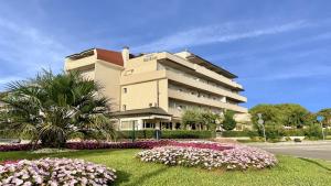 a large building with flowers in front of it at Hotel Old River in Lignano Sabbiadoro