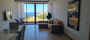 a living room with a couch and a view of the ocean at Praia Modern Apartment vista Mar in Praia