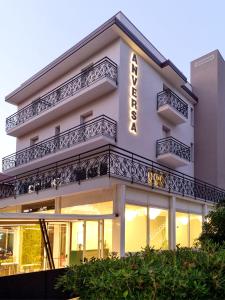 a white building with a sign on it at Hotel Anversa Rimini in Rimini