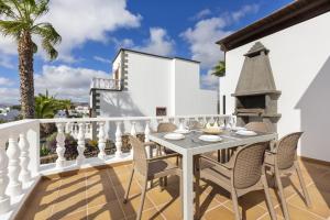 een patio met een tafel en stoelen op een balkon bij Villa Reymar in Tías