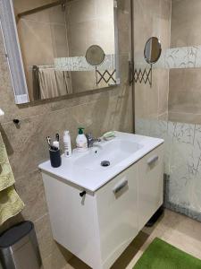 ein Badezimmer mit einem weißen Waschbecken und einer Dusche in der Unterkunft APPARTEMENT BORDURE PLAGE in Kenitra