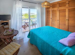 a bedroom with a bed and a table and a balcony at Casa en Ibiza con vistas increíbles en Es Figueral in Es Figueral Beach