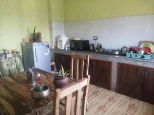 a kitchen with a wooden table and a refrigerator at calmsutra in Kathmandu