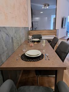 a table with plates and wine glasses on it at Stunning new apartment with free parking near city centre in Ljubljana