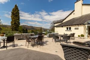 a patio with tables and chairs in front of a building at Lakes Hotel & Spa in Bowness-on-Windermere