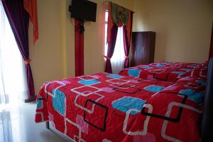 1 dormitorio con 1 cama con edredón rojo y azul en Hotel Élite Internacional, en Guayaquil