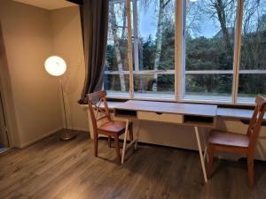 a room with a desk and two chairs and a window at Lakeside Studio near Amsterdam in Warder