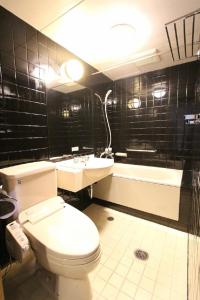 那霸的住宿－HOTEL LiVEMAX BUDGET Okinawa Tomariko，浴室配有卫生间、盥洗盆和浴缸。