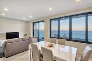 a living room with a white table and a couch at Spacious Seafront 3BR, Sliema near Beach, AC Wifi by 360 Estates in Sliema