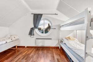 a bedroom with two bunk beds and a window at Auroras Friends Apartment in Tromsø