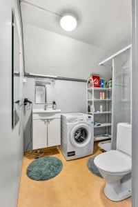 a bathroom with a washing machine and a toilet at Auroras Friends Apartment in Tromsø
