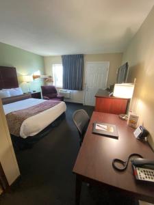 Habitación de hotel con cama y escritorio en Boarders Inn & Suites by Cobblestone Hotels - Broken Bow en Broken Bow
