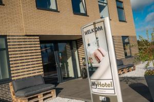 a sign in front of a building with a refrigerator at MyHotel Steenwijk - Giethoorn in Steenwijk