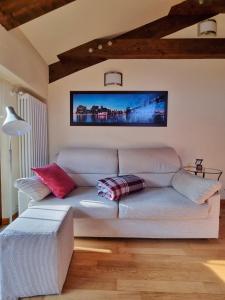 salon z kanapą i telewizorem na ścianie w obiekcie Saluzzo Historic Center Apartment w mieście Saluzzo
