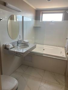 ein Badezimmer mit einem Waschbecken, einem WC und einem Spiegel in der Unterkunft Hotel Marques in Araras