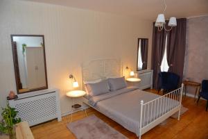 1 dormitorio con 1 cama, 2 mesas y espejo en Family Residence, en Sibiu