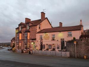 un grand bâtiment sur le côté d'une rue dans l'établissement Ye Olde Fighting Cocks, à Arnside