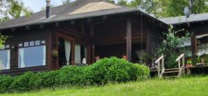 une maison en bois avec une terrasse couverte sur une colline dans l'établissement Cabaña para 5 personas, Villarrica-Pucón con vista privilegiada ., à Villarrica