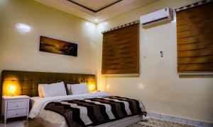 Nouakchott INN في نواكشوط: غرفة نوم بها سرير مع مصباحين