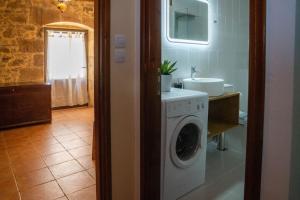 a bathroom with a washing machine and a sink at IOANNIS STONEHOUSE, Quiet, Privacy & Sea View. in Kissamos
