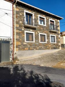 um edifício de tijolos com janelas e uma varanda em Casa rural Las Peñas em Saucelle