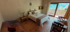 a bedroom with a white bed and a balcony at Gocta Miradors Deluxe in Cocachimba
